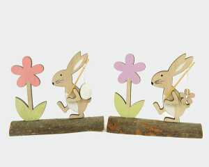 Hase aus Holz mit Ei und Blume auf Holzstamm