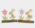 Hase aus Holz mit Ei und Blume auf Holzstamm